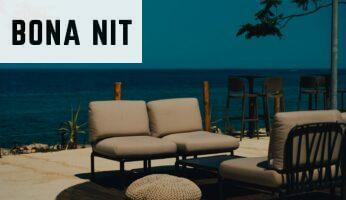 A couch and chair sitting on a patio next to the ocean
