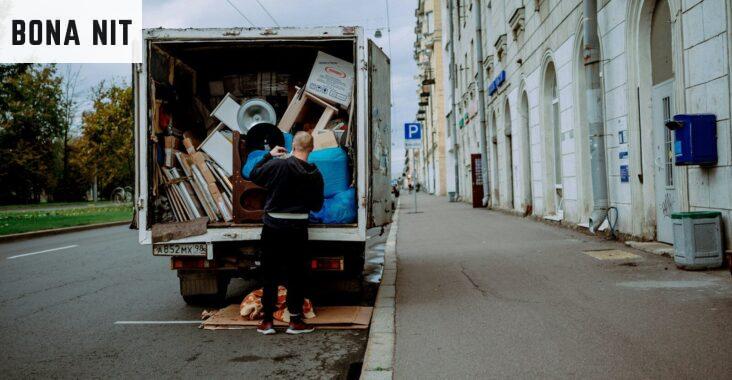 a man unloading furniture from the back of a moving truck